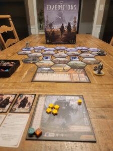 Expeditions board game being played on a table.