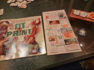 Fit to Print Board Game instructions on a table.